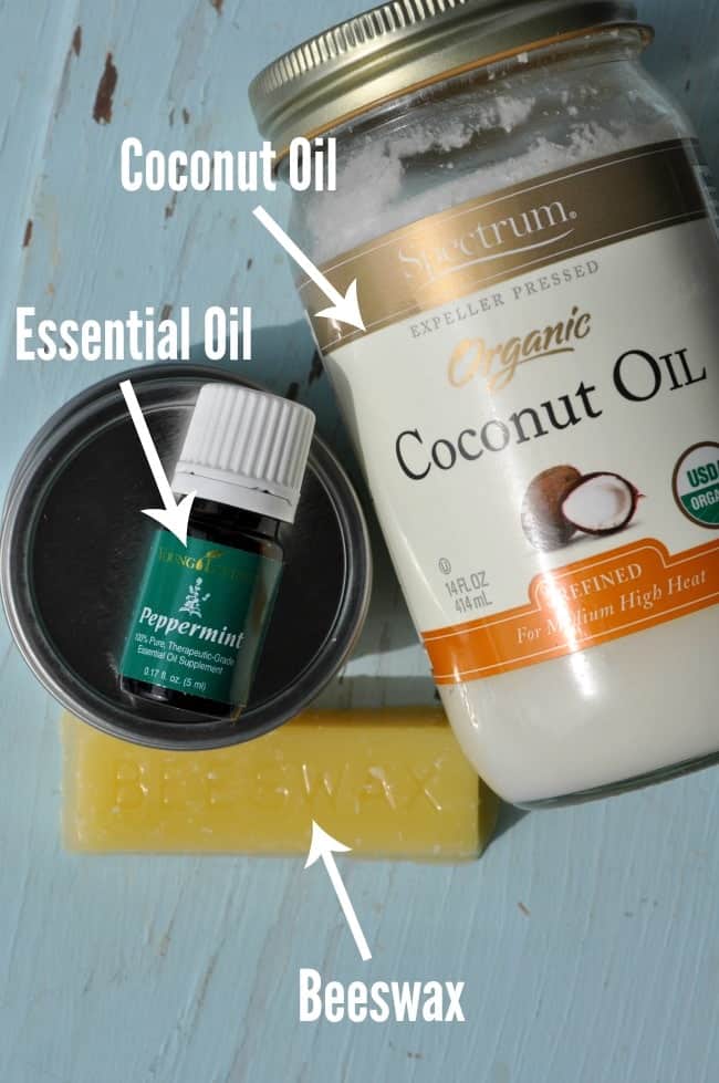 A jar of coconut oil, a small bottle of Peppermint essential oil, and a bar of organic beeswax - the main ingredients needed to make homemade lip balm.