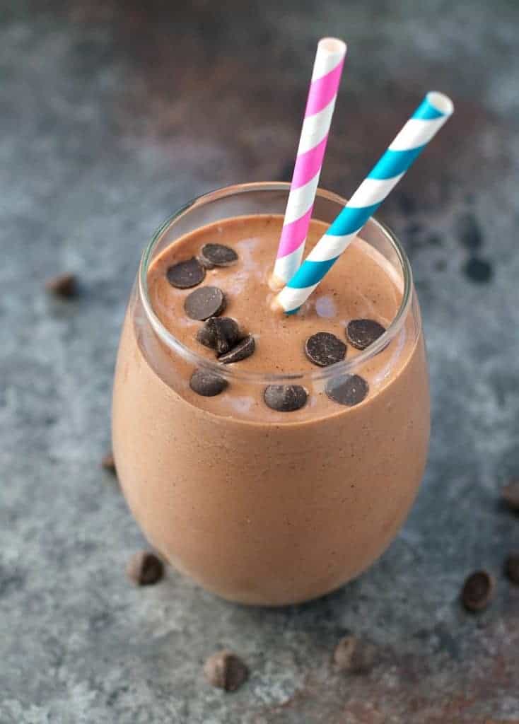 Healthy Smoothie with chocolate banana and peanut butter in a glass with two straws