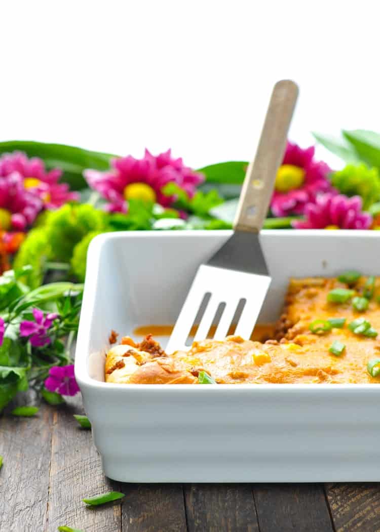 Ground beef casserole in a white dish with a spatula