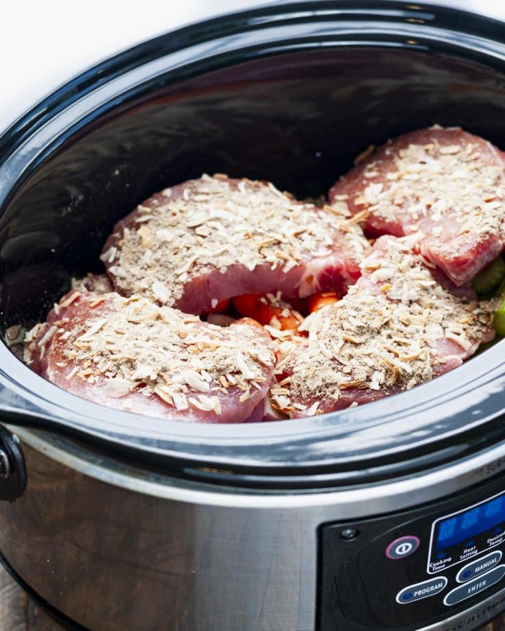 Sprinkling onion soup mix on top of pork chops in a Crock Pot.