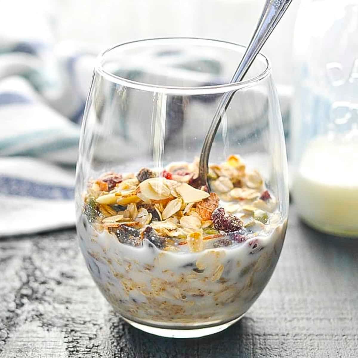 Square side shot of a glass of the best Swiss muesli recipe with milk.