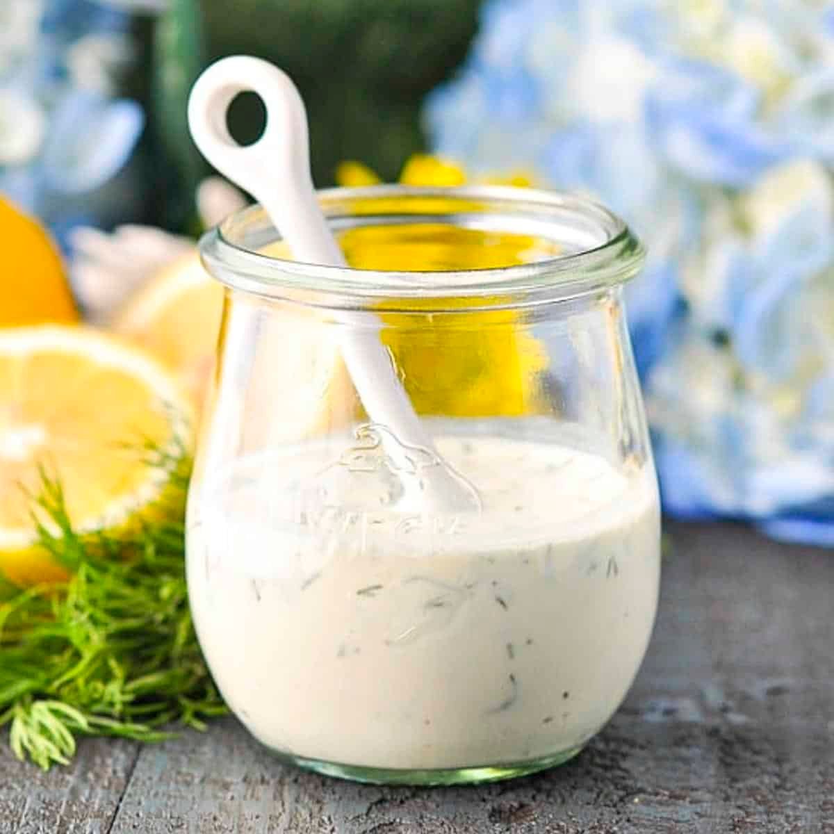 Square side shot of homemade buttermilk dressing in a glass jar.