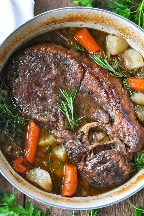 Close overhead shot of dutch oven pot roast with carrots and potatoes