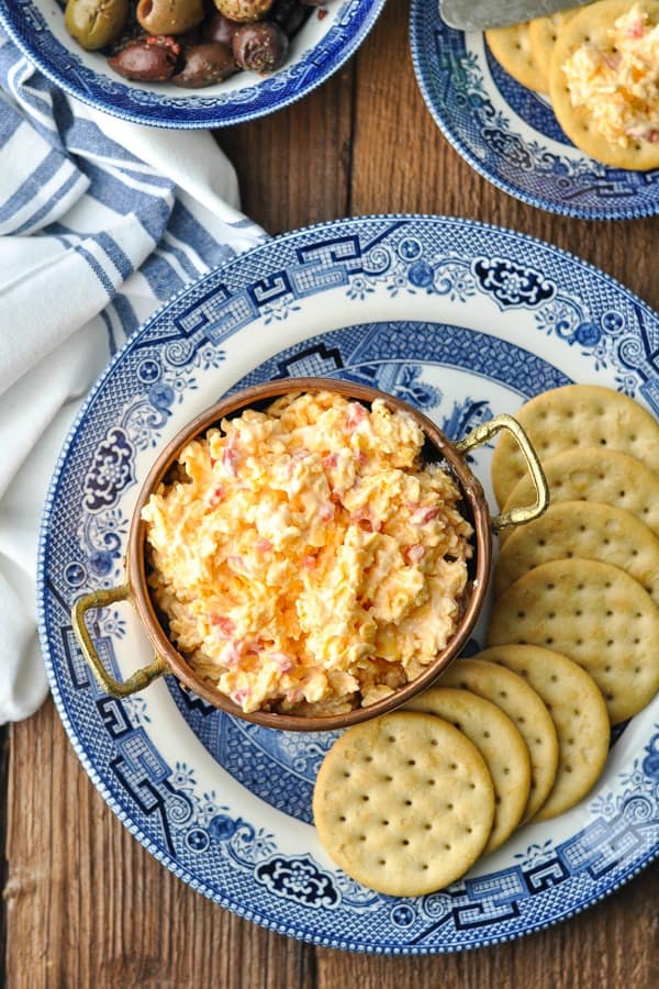 Overhead shot of a plate of pimento cheese and crackers on a wooden table
