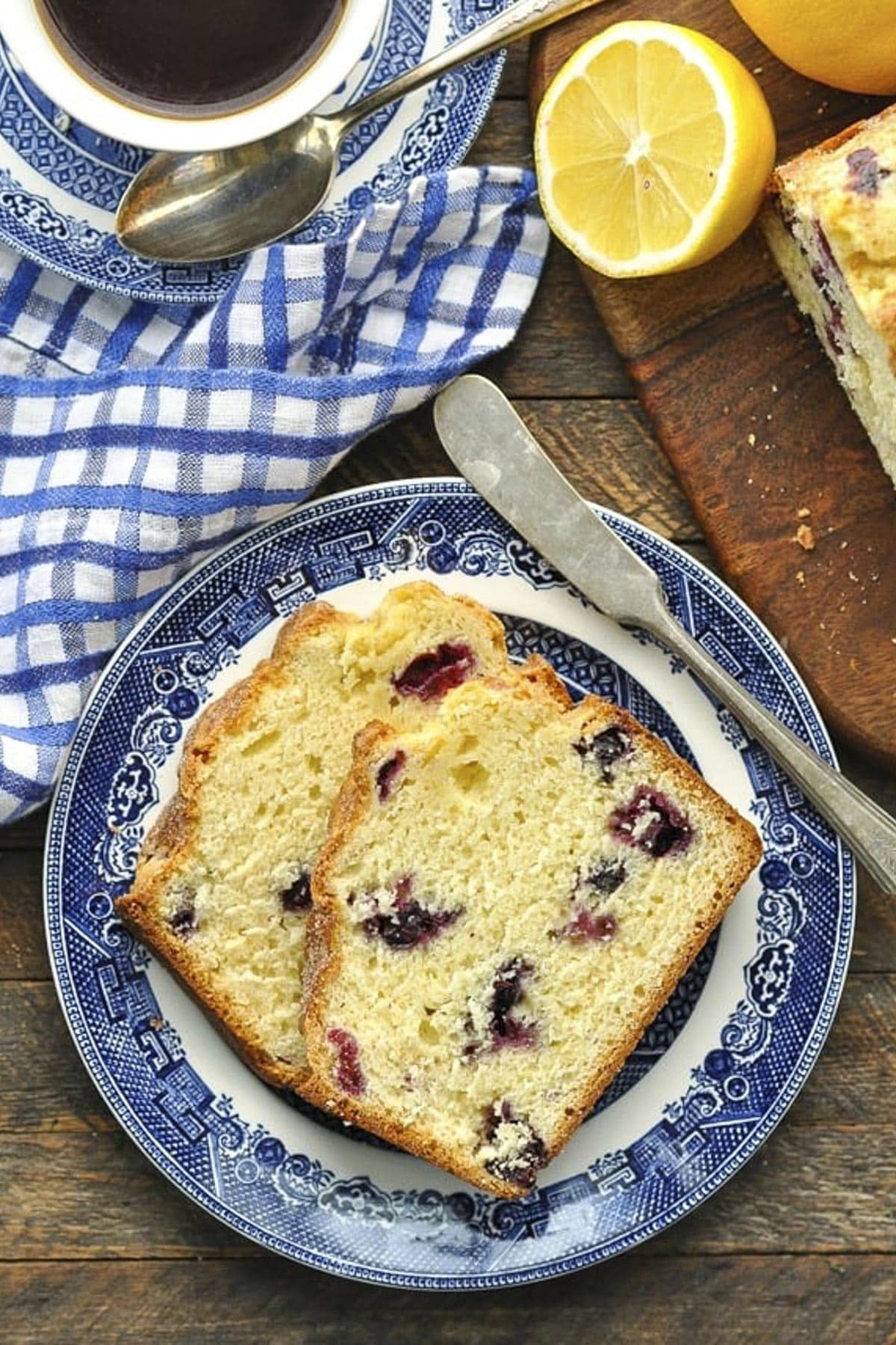 Overhead shot of a plate of lemon blueberry bread on a wooden table.