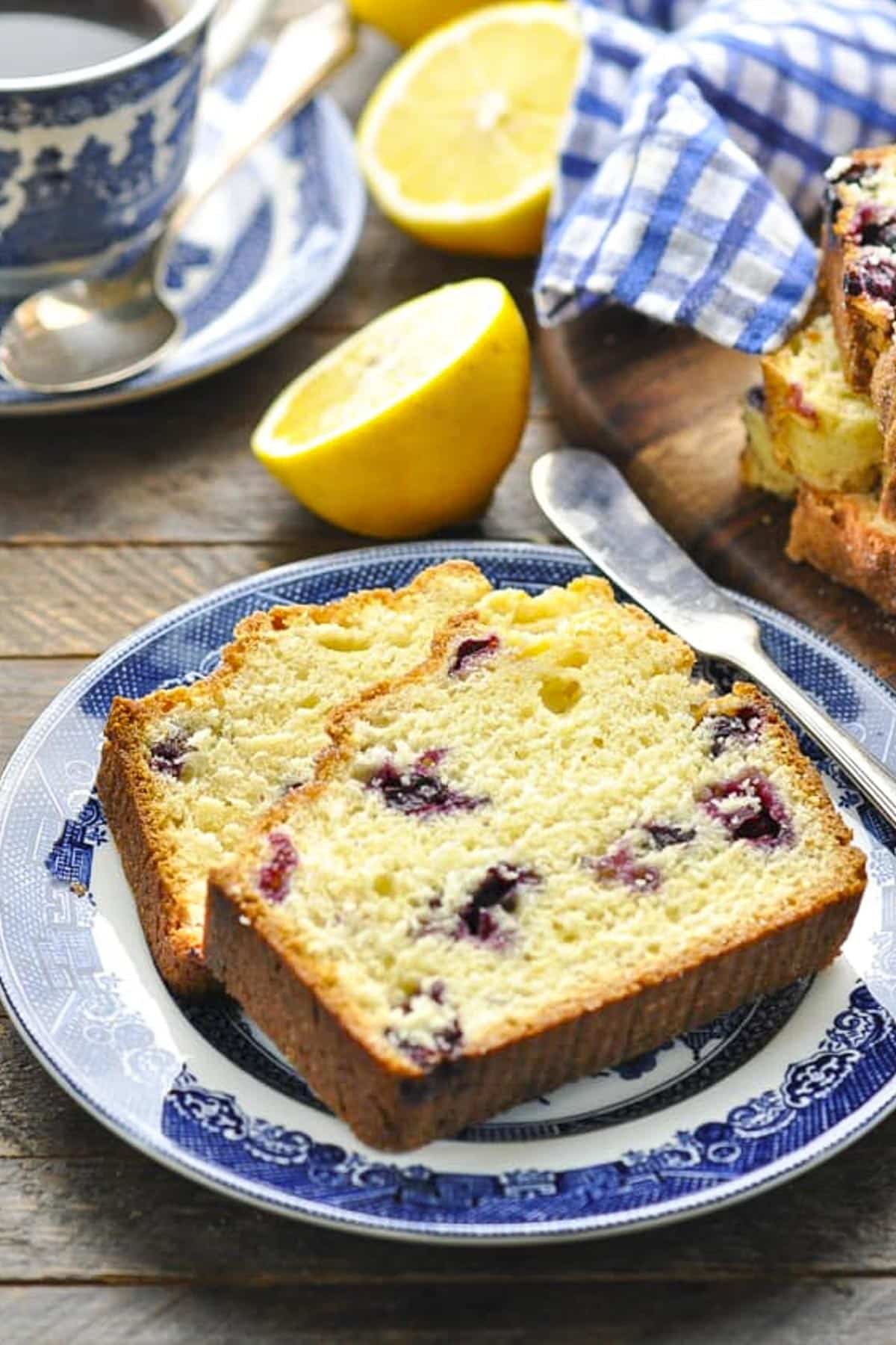 Side shot of two slices of lemon blueberry bread on a plate.