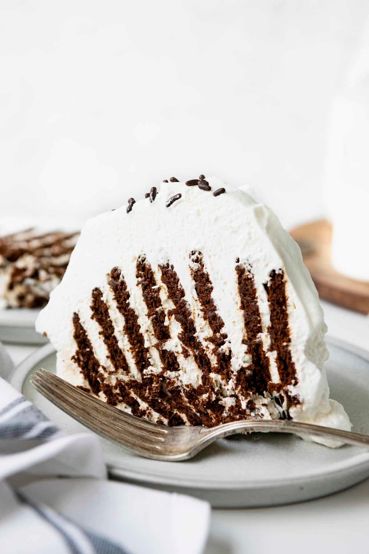 Side shot of the best recipe for icebox cake on a white plate.