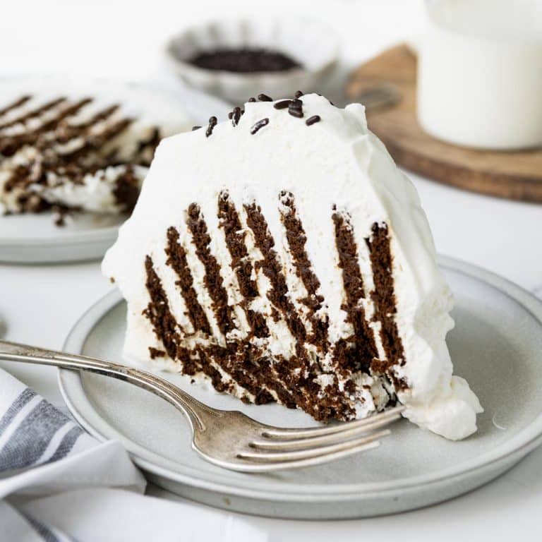 Square side shot of a slice of classic icebox cake on a white plate.