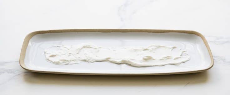 A spread of whipped cream on a long white platter.