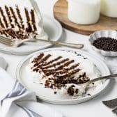 Horizontal shot of a slice of chocolate icebox cake on a white plate.