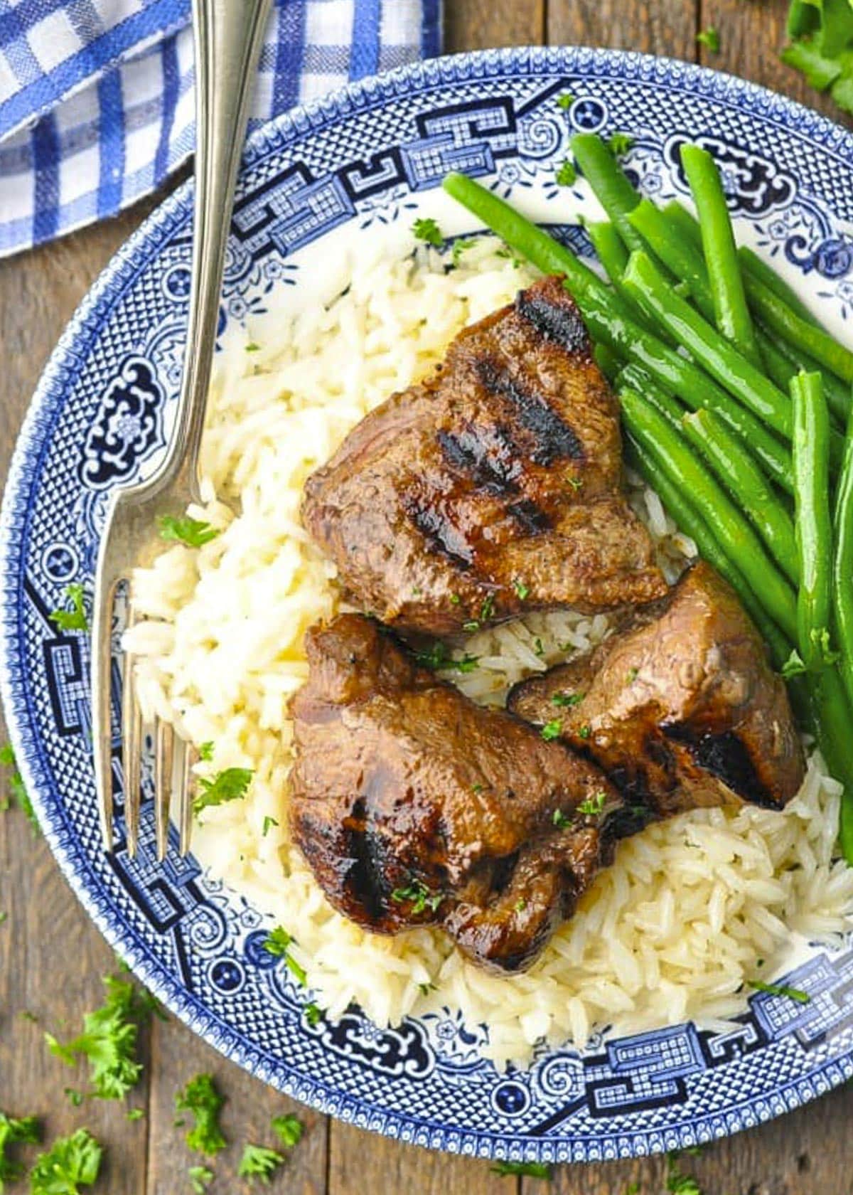 Marinated grilled steak tip recipe served on rice with a side of green beans.
