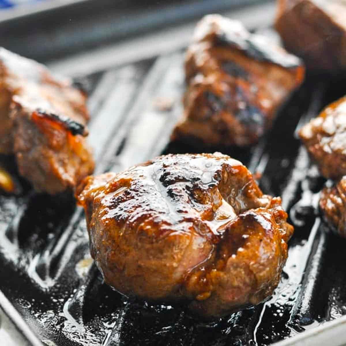 Square side shot of grilled steak tips.