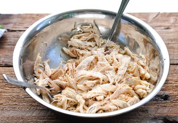 Shredded chicken in a metal mixing bowl