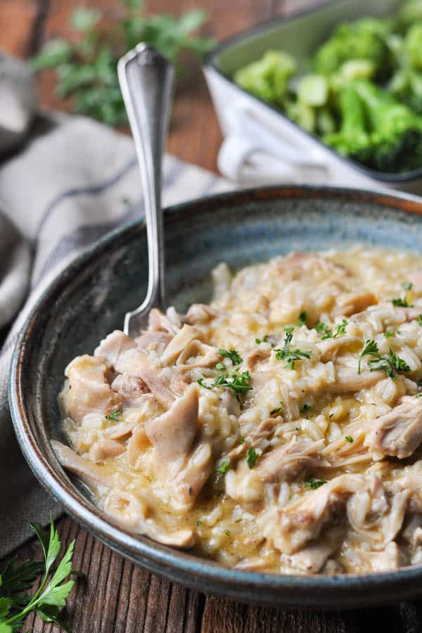 Front shot of a fork in a bowl of slow cooker chicken with rice and mushroom soup