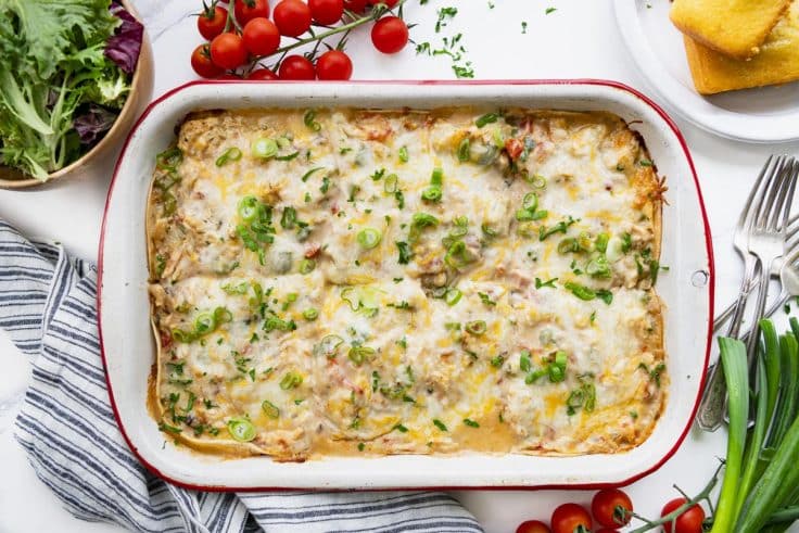 Horizontal overhead shot of a baked king ranch chicken casserole on a white table.