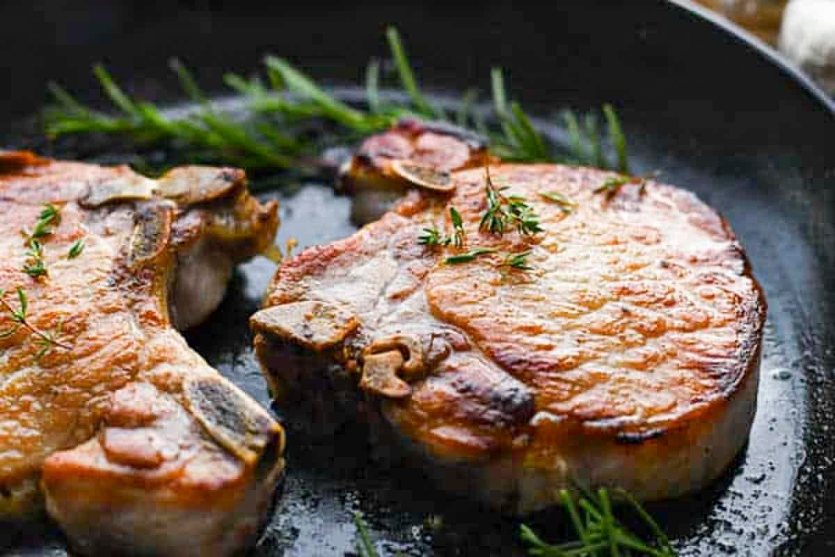 Brined and cooked pork chops in a cast iron pan.