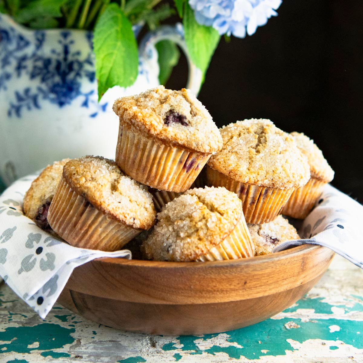Square side shot of a bowl of blackberry muffins.