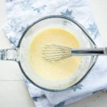 Egg and buttermilk mixture in glass bowl with whisk