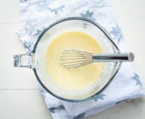 Egg and buttermilk mixture in glass bowl with whisk
