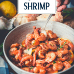 Side shot of a bowl of garlic butter shrimp with text title overlay