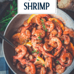 Close overhead shot of a bowl of garlic butter shrimp with text title overlay
