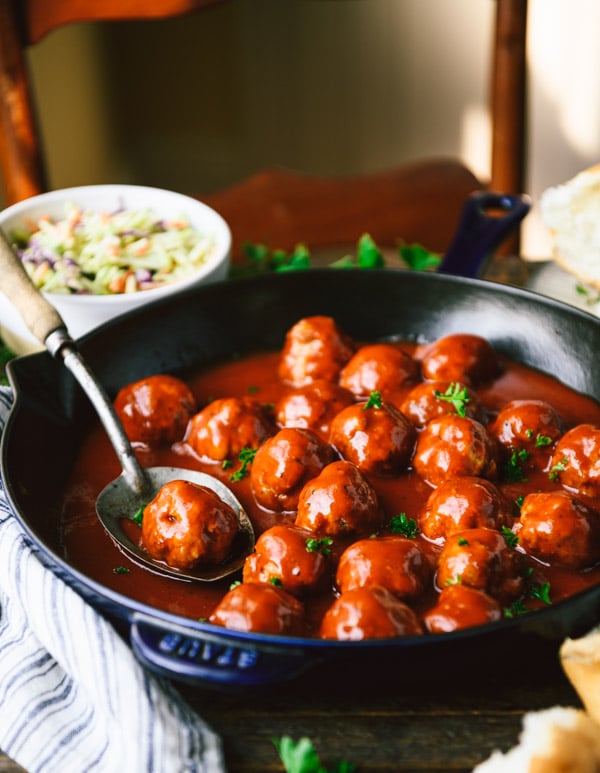 Side shot of a skillet of bbq meatballs on a dinner table