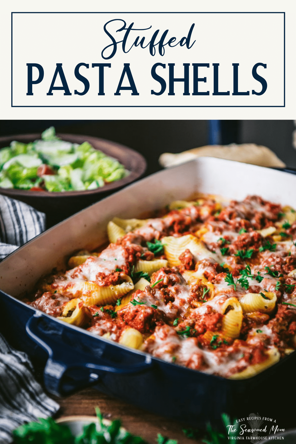 Side shot of stuffed shells with meat sauce in a pan with text title box at top