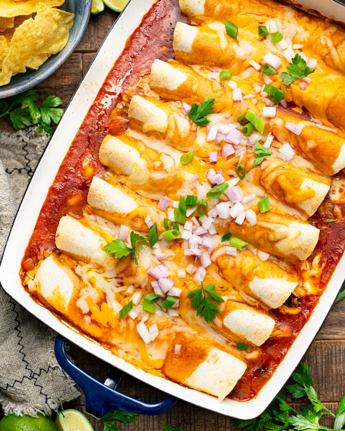 Overhead shot of easy chicken enchiladas on a wooden table.