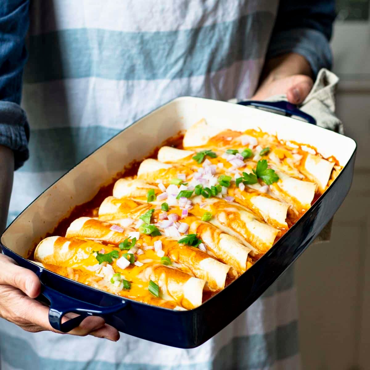 Square side shot of a pan of easy chicken enchiladas.