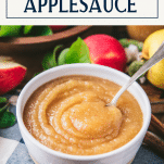 Spoon in a serving bowl of homemade applesauce with text title box at top