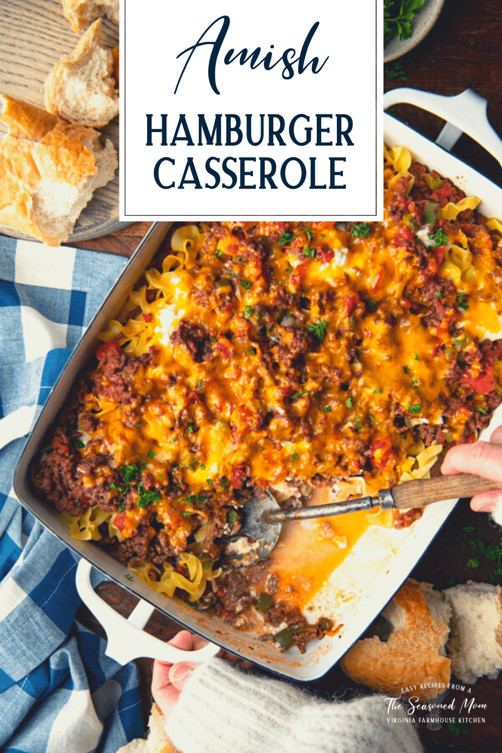 Overhead shot of a spoon in a pan of hamburger noodle casserole with text title overlay