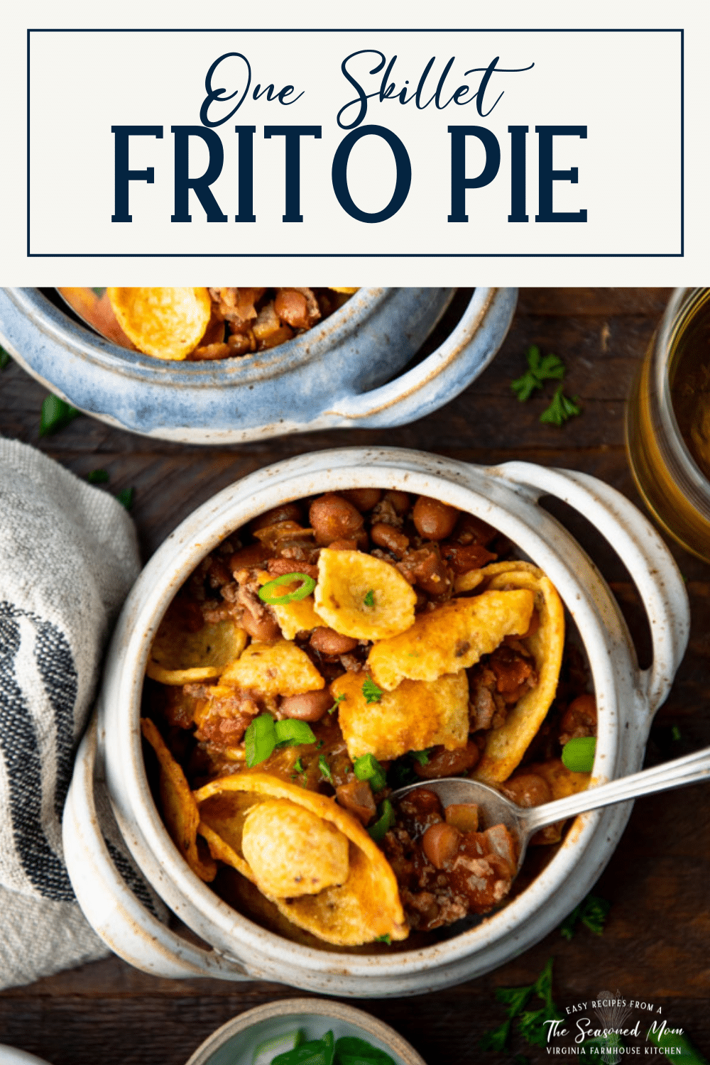 Overhead shot of a spoon in a bowl of frito pie with text title box at top