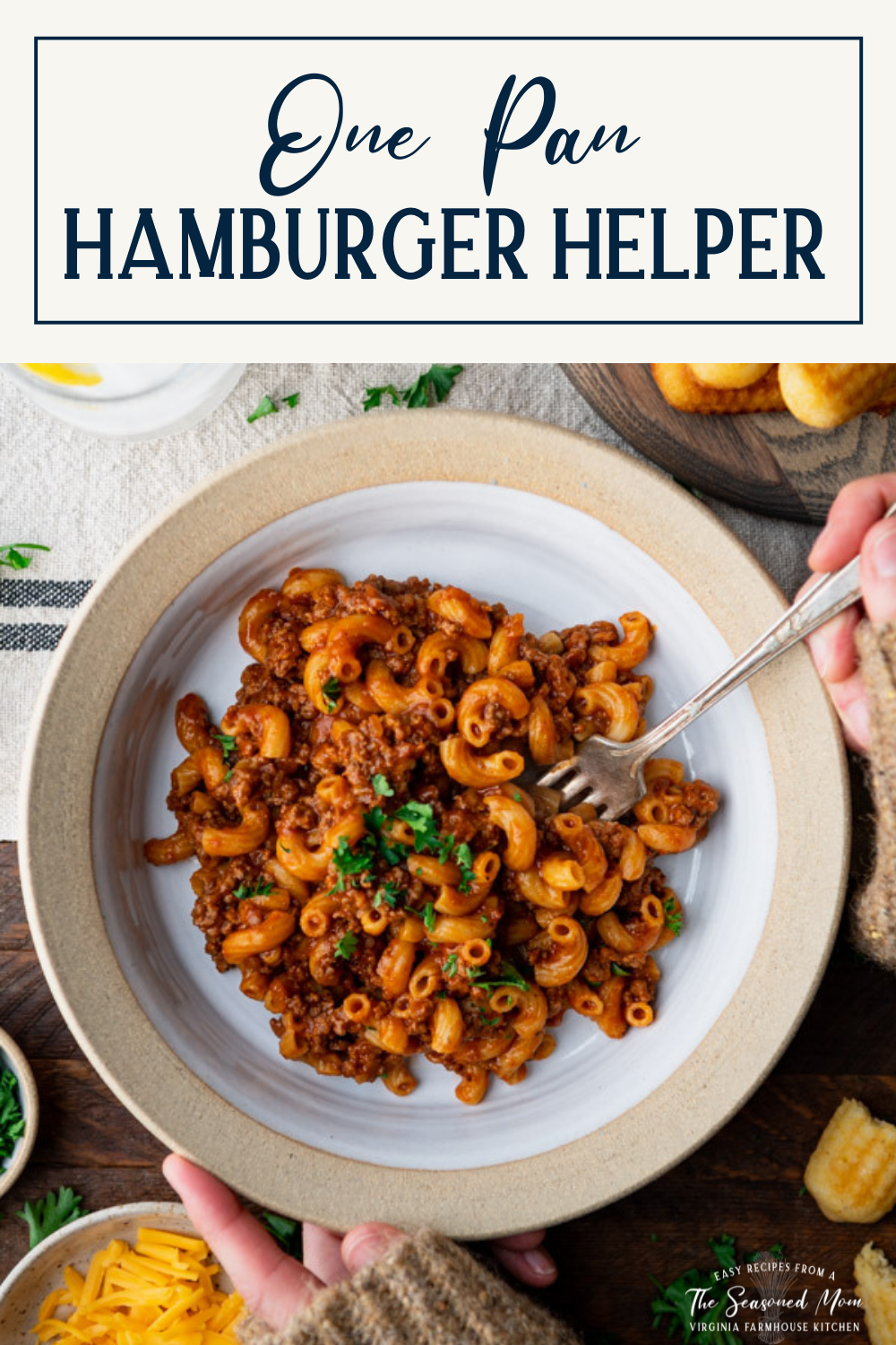 Overhead image of hands eating a bowl of homemade hamburger helper with text title box at top.