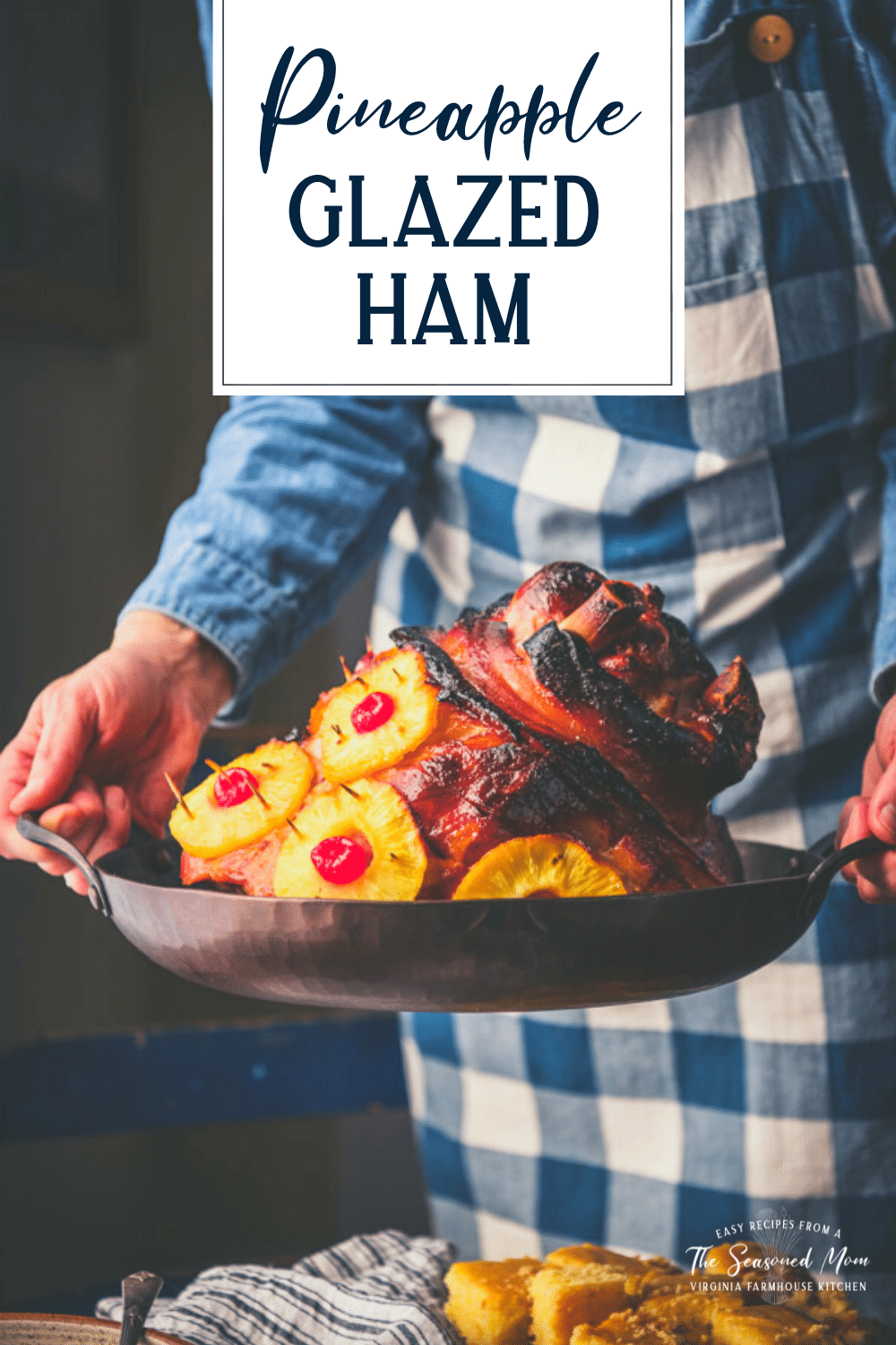 Side shot of hands holding a roasting pan with pineapple glazed ham with text title overlay.