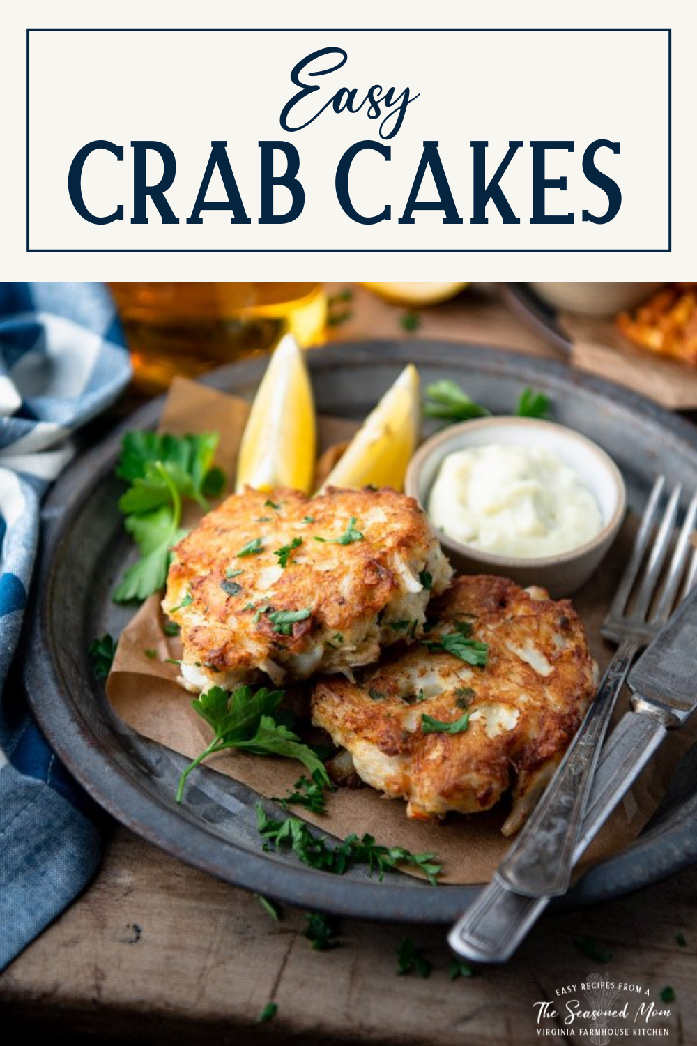 Side shot of a plate of two crab cakes with text title box at top