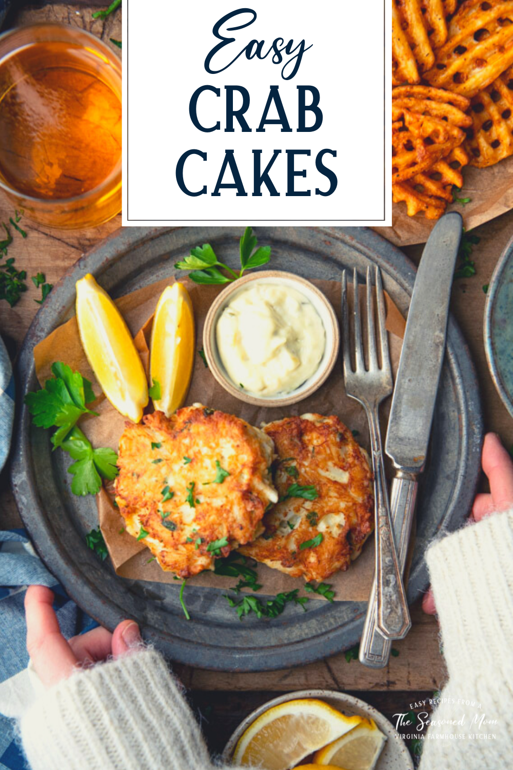 Hands holding a plate of crab cakes with text title overlay