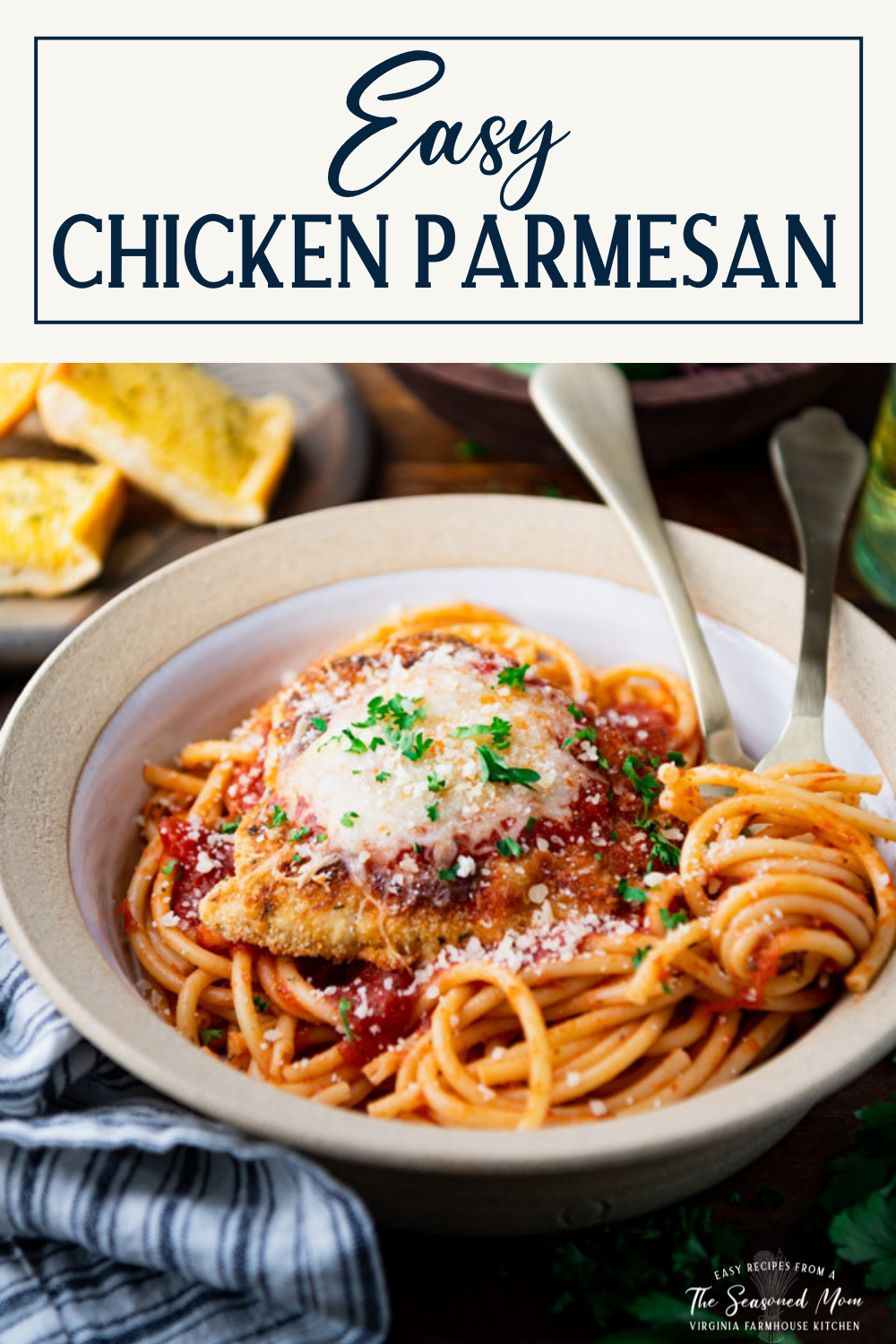 Close up side shot of a bowl of crispy fried and baked chicken parmesan served with spaghetti, bread, and salad and text title box at top.