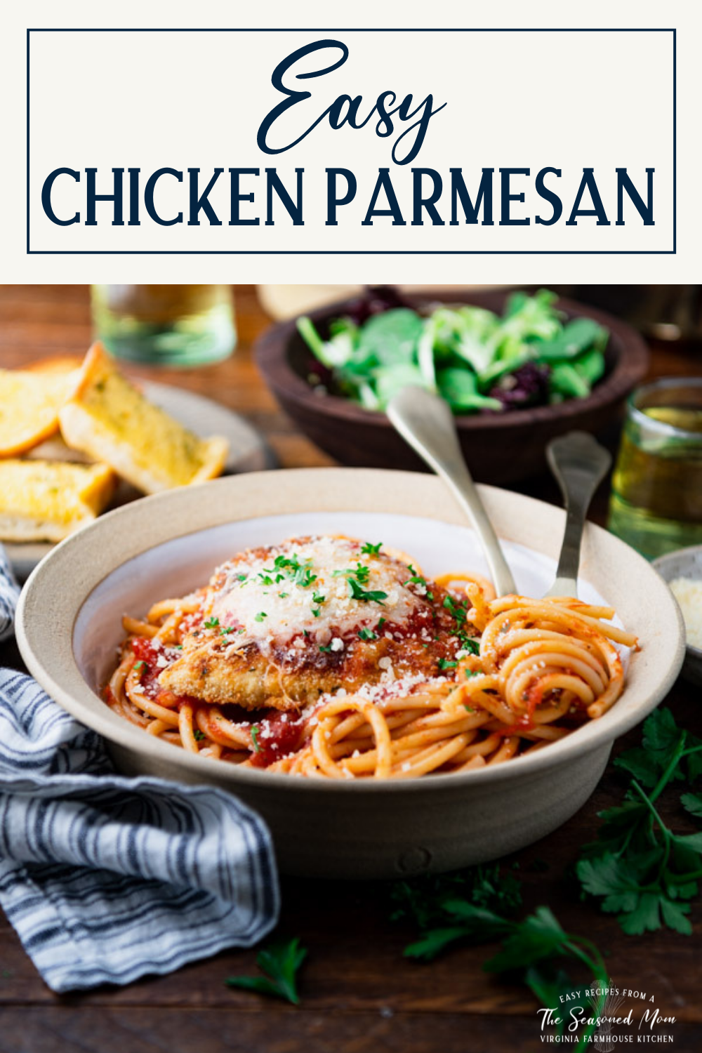 Side shot of chicken parmesan recipe on a dinner table with text title box at top