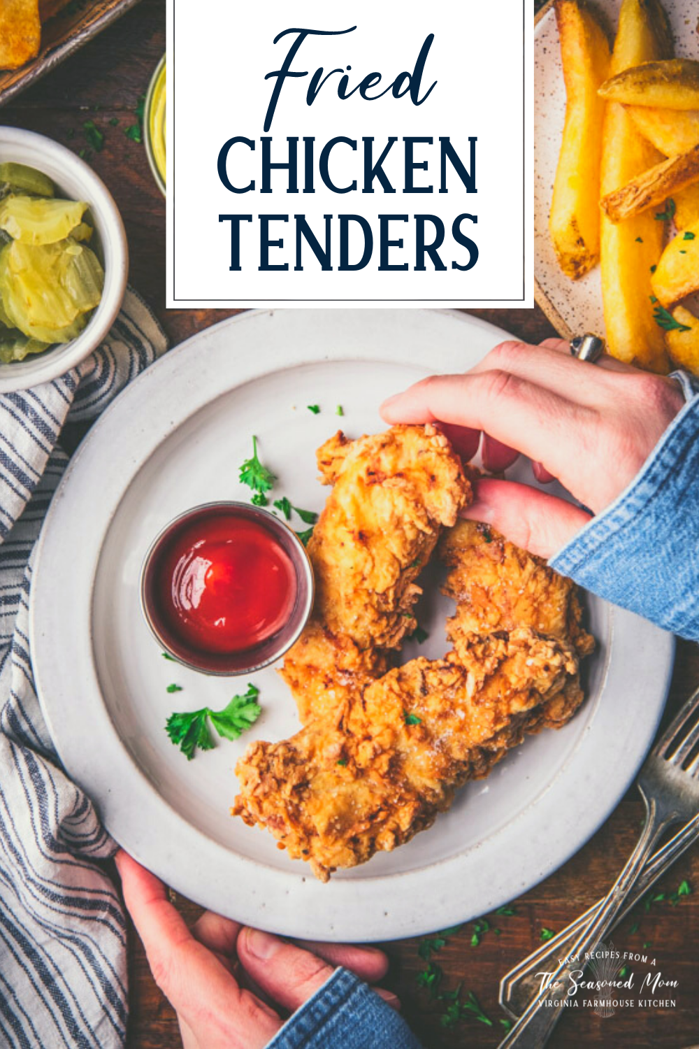 Hands eating crispy fried chicken tenders on a white plate with text title overlay