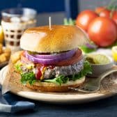 Horizontal image of the best grilled burger recipe on a plate.
