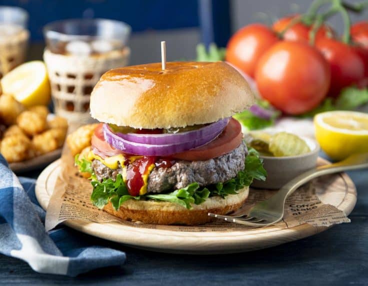 Horizontal image of the best grilled burger recipe on a plate.