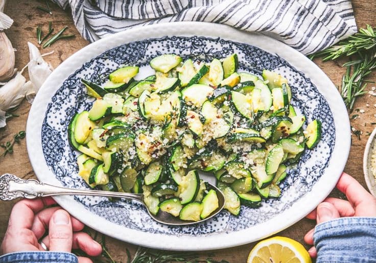 Horizontal overhead shot of sauteed zucchini on a blue and white oval plate.