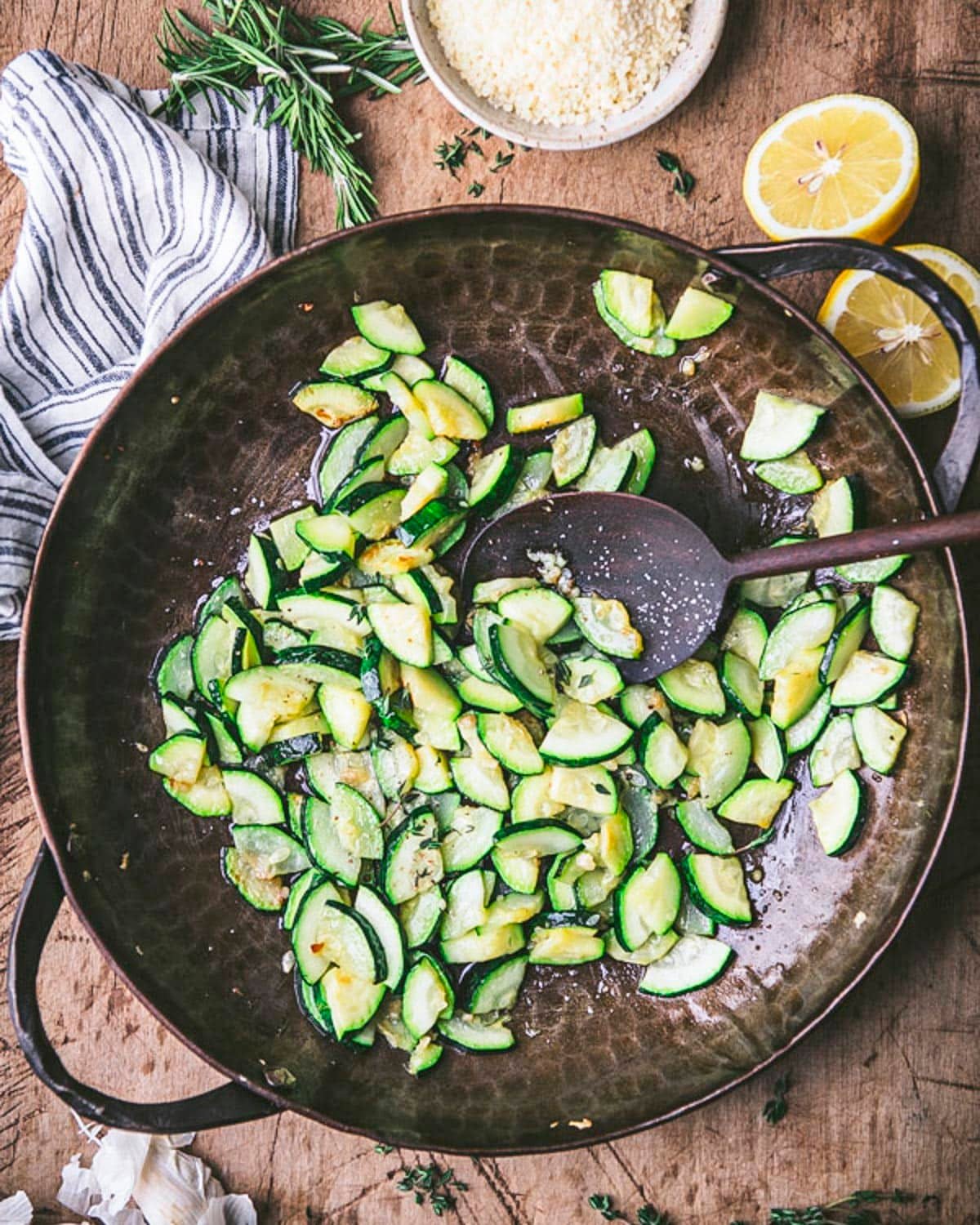 Overhead shot showing how to saute zucchini in a cast iron skillet.