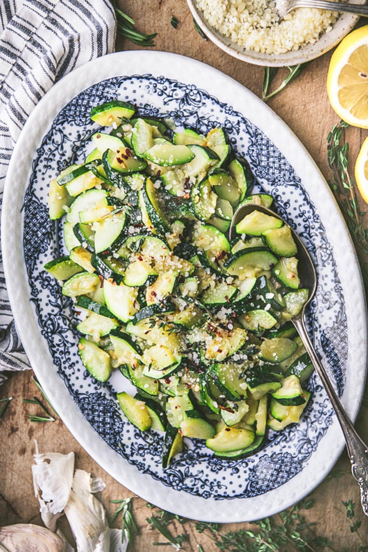 The best seasonings for zucchini on a bed of sauteed zucchini on a blue and white plate.