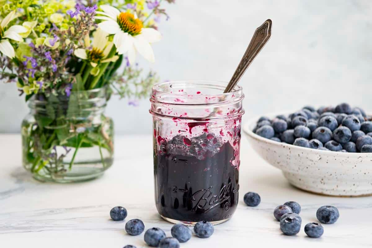 Horizontal side shot of a jar of blueberry jam.