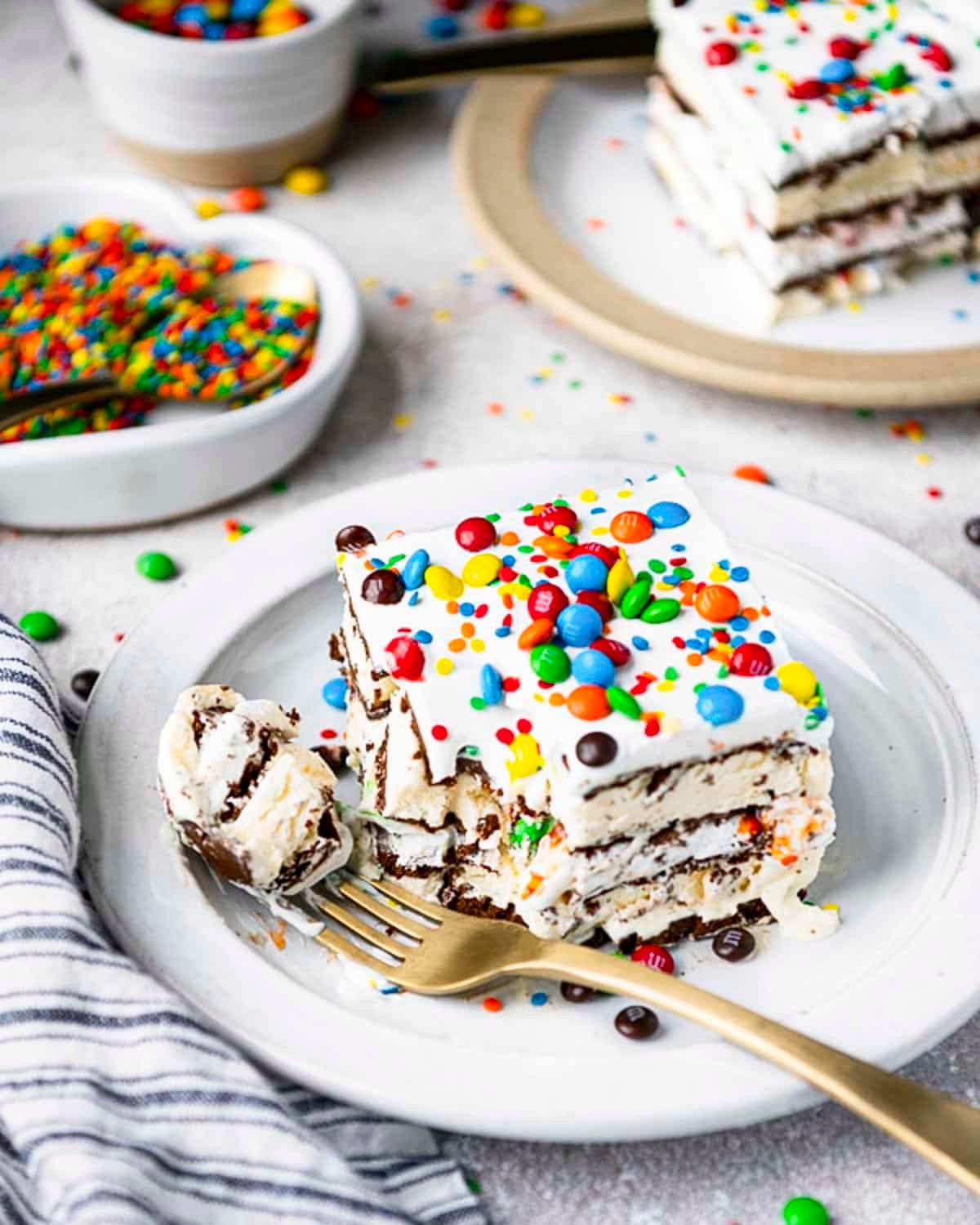 Side shot of slices of ice cream sandwich cake on a white table.