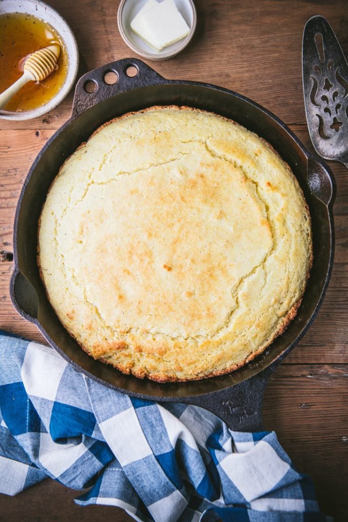Overhead shot of a Southern cornbread recipe in a cast iron skillet on a wooden table