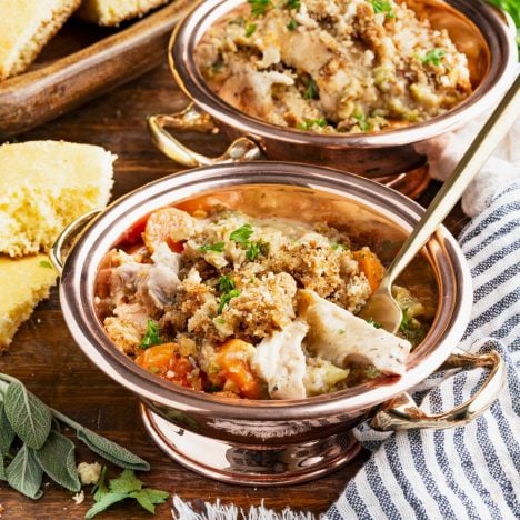 Square side shot of a copper bowl full of crockpot chicken and stuffing.