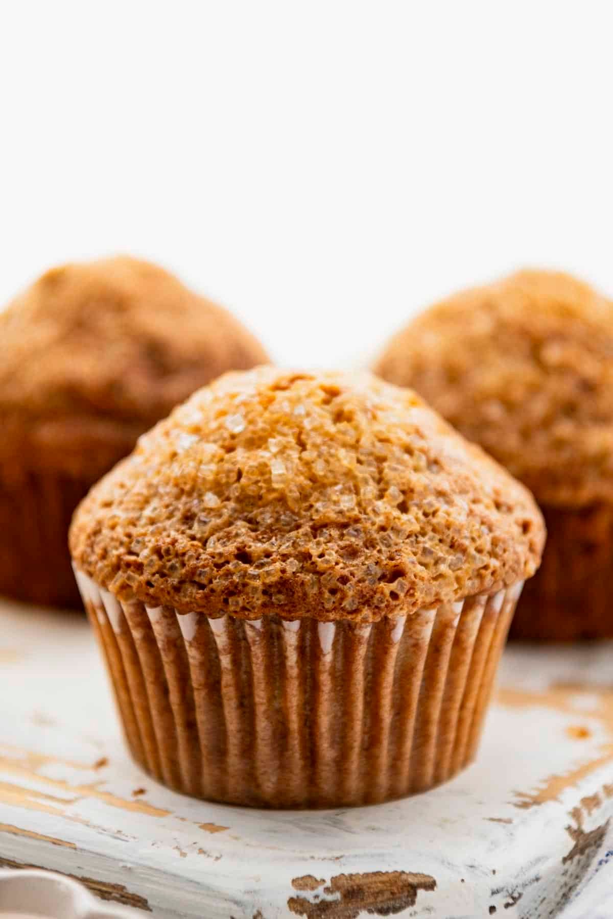 Close up front shot of a moist banana nut muffins recipe on a white table.