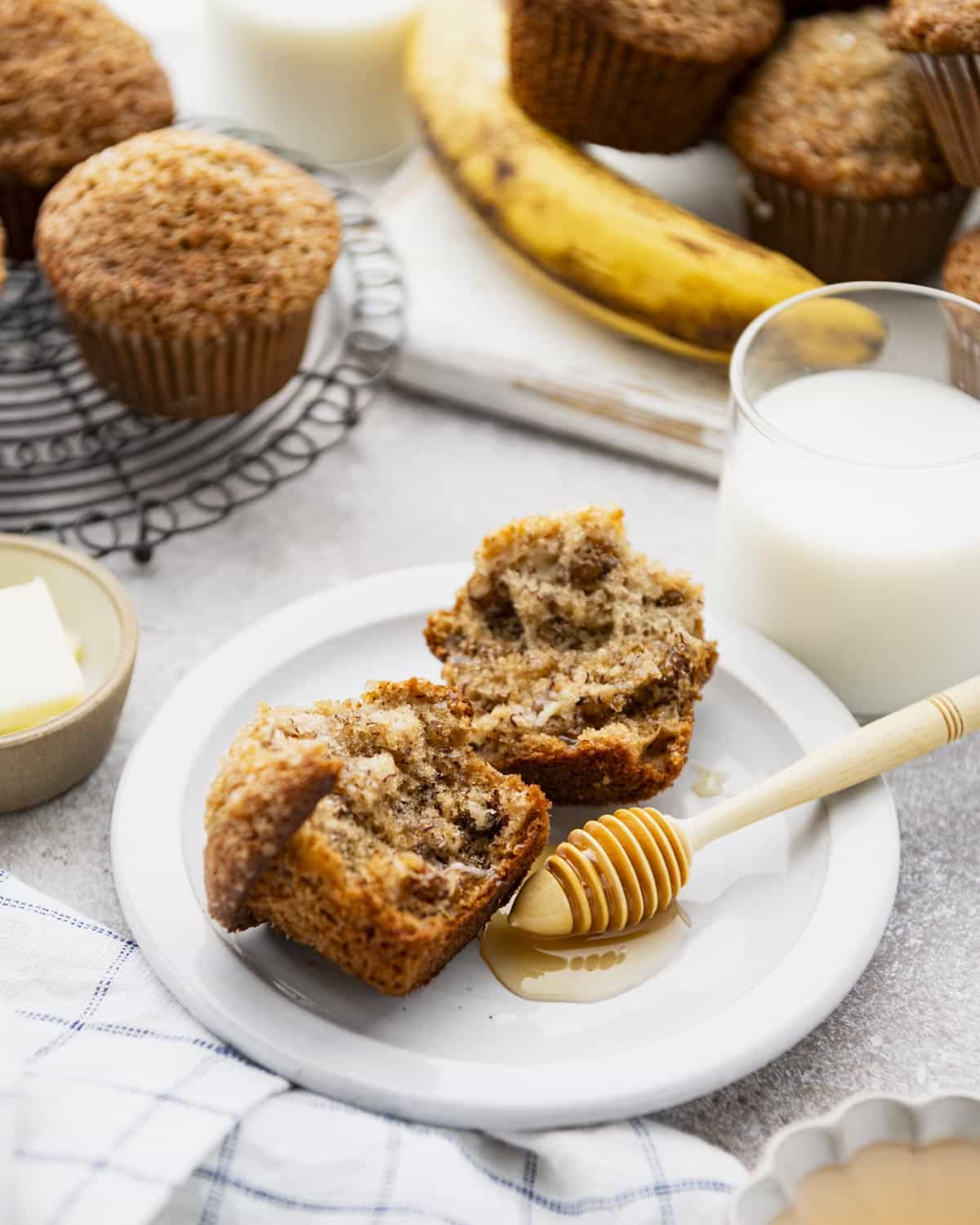 The best banana nut muffin recipe served on a white plate with a glass of milk.